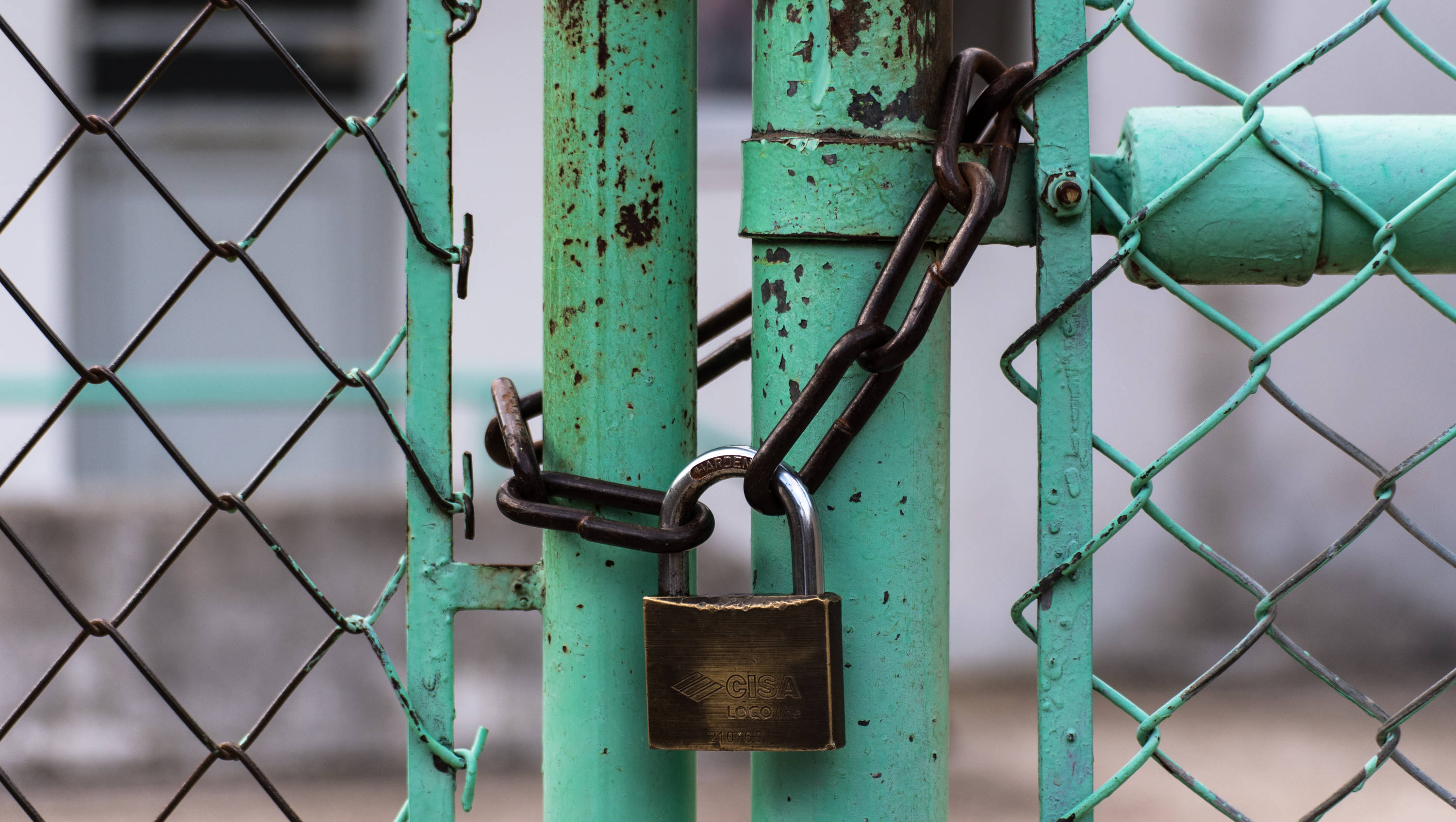 A padlock that locks a chain around a gate