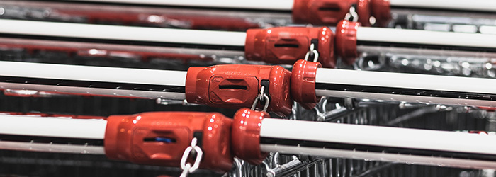 A row of shopping trolleys chained together, focusing on the coin locks