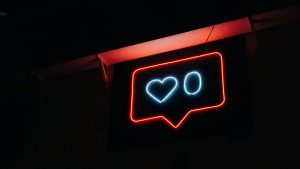 A neon sign that looks like the Instagram heart icon with a zero next to it