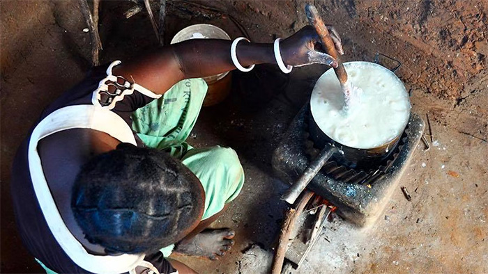 A woman is cooking on the top of a new cookstove.