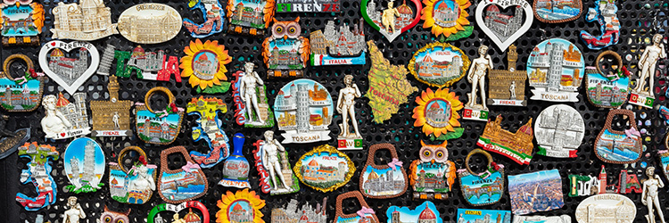 Photo of a huge range of Italy-themed fridge magnets on a metal board.
